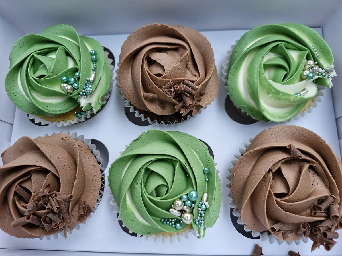 Hand-decorated cupcakes topped with green and brown buttercream and sprinkles.